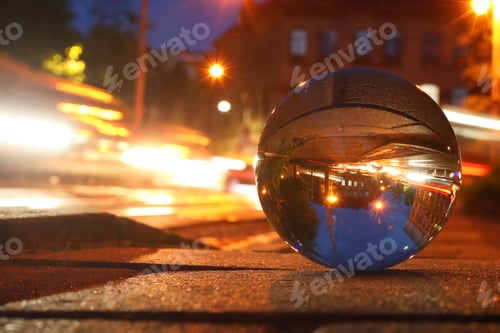 Preview: Beautiful city street, overturned reflection. Crystal ball on asphalt road at night. Space for text