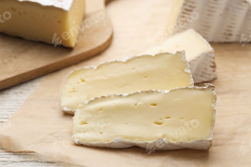Preview: Slices of delicious brie cheese on color wooden table, closeup
