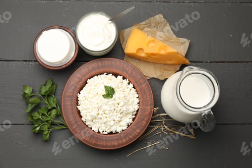 Preview: Different dairy products and parsley on black wooden table, flat lay