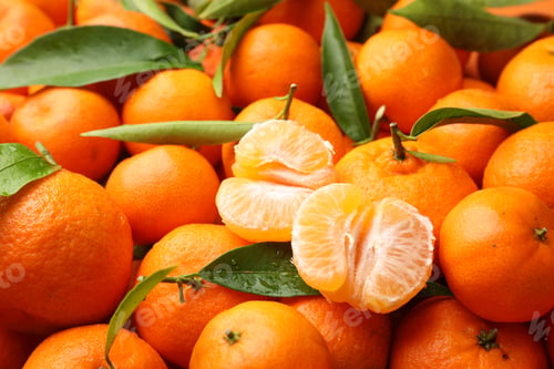Preview: Many fresh ripe tangerines with green leaves and water drops as background