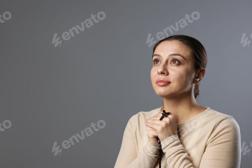 Vista previa: Woman with cross praying on light grey background, space for text