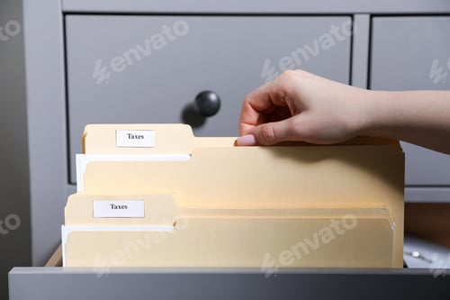 Preview: Tax. Woman taking folder from drawer of cabinet in office, closeup