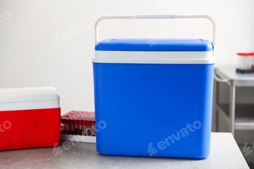 Preview: Cool boxes and test tubes of blood samples on grey table in clinic, closeup