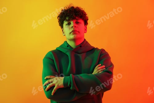 Preview: Portrait of young hip-hop dancer in neon light on orange background
