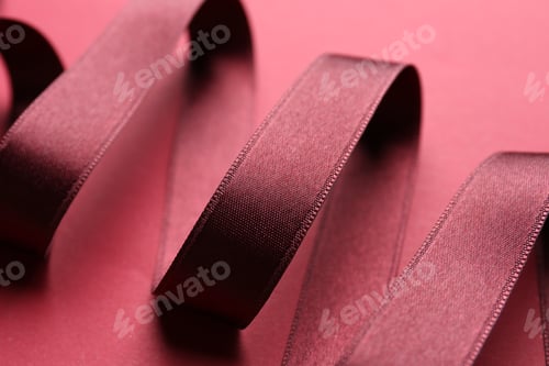 Preview: Beautiful maroon ribbon on red background, closeup