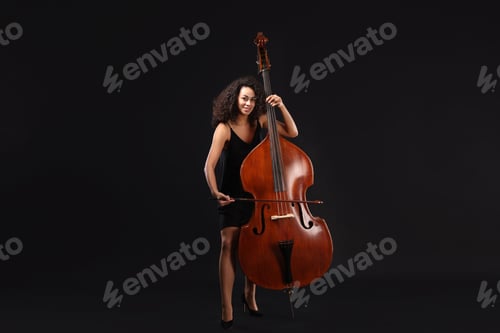 Preview: Woman playing double bass on black background