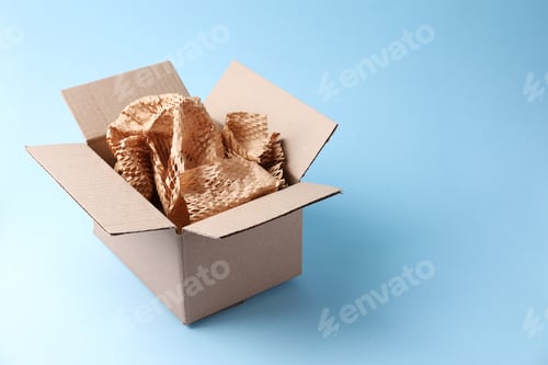 Preview: Cardboard box with honeycomb paper on light blue background. Space for text