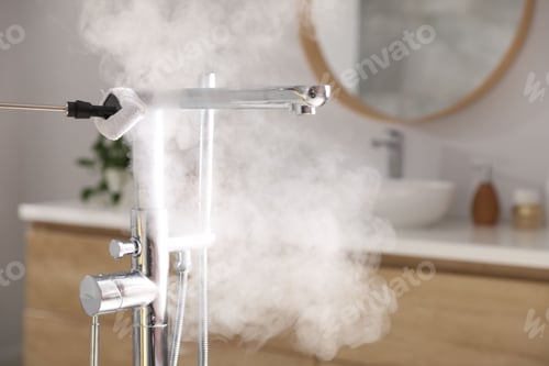 Preview: Cleaning faucet with steam cleaner in bathroom, closeup