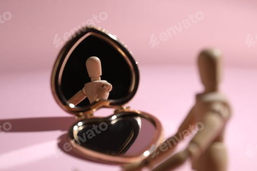 Preview: Wooden mannequin with pocket mirror on pink background, closeup