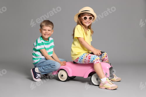Preview: Little children with toy car on grey background