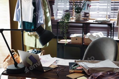 Preview: Fashion designer's workplace with sketches of outfits, stationery and laptop on wooden table indoors