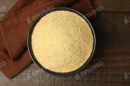 Preview: Raw semolina in bowl on wooden table, top view
