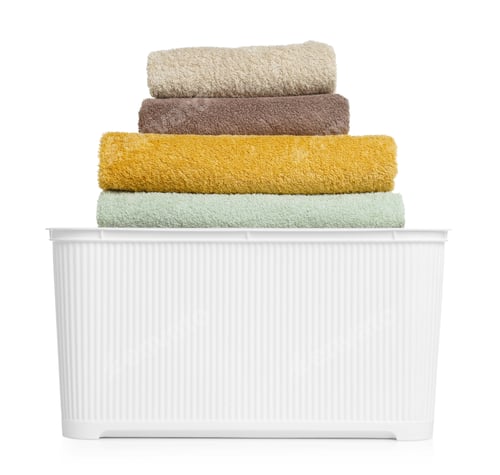 Preview: Many soft clean towels in laundry basket isolated on white