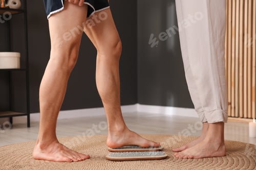 Preview: Young woman and man standing on sadhu boards at home, closeup