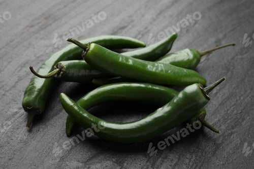 Preview: Green chili peppers on grey textured table, closeup