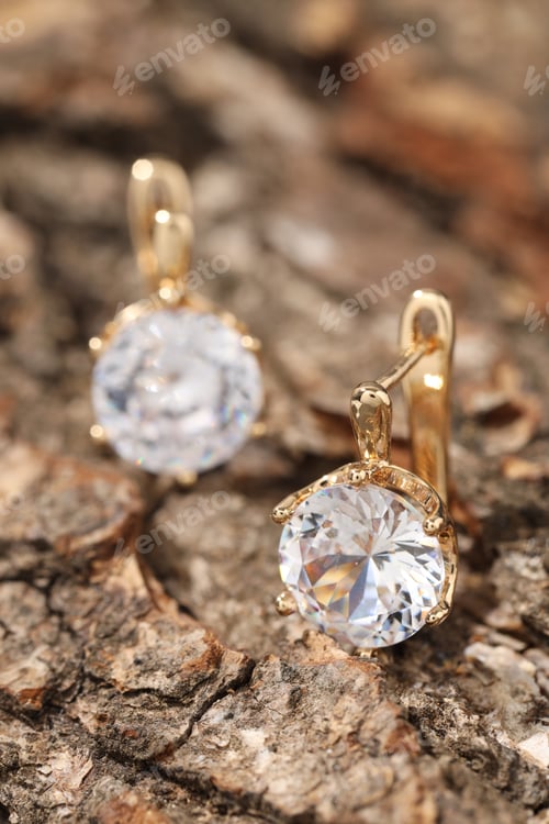 Preview: Pair of elegant earrings on wooden surface, closeup
