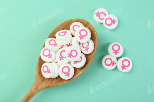 Preview: Female hormones. Pills with female gender symbols on turquoise background, top view