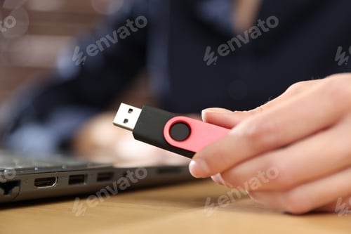 Preview: Woman with USB flash drive working on laptop at desk, closeup