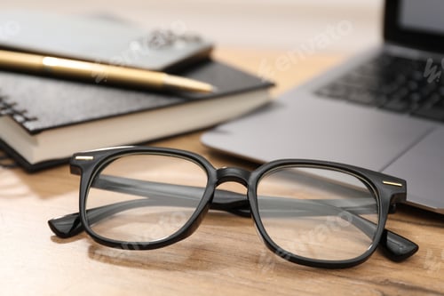 Preview: Pair of stylish glasses on wooden table indoors, closeup