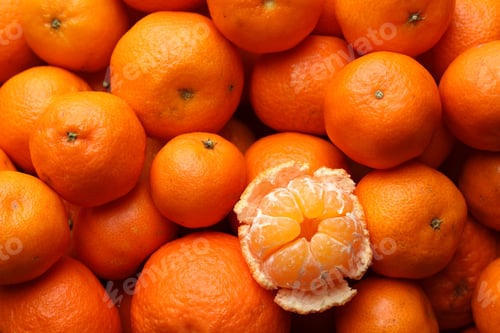 Preview: Many whole tangerines and one peeled as background, top view