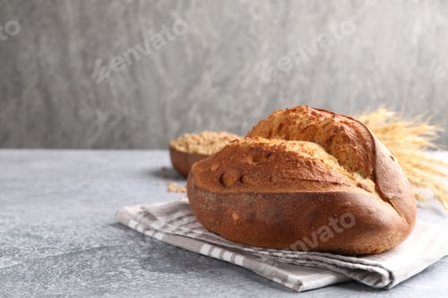 Preview: Loaf of sourdough bread on grey table. Space for text