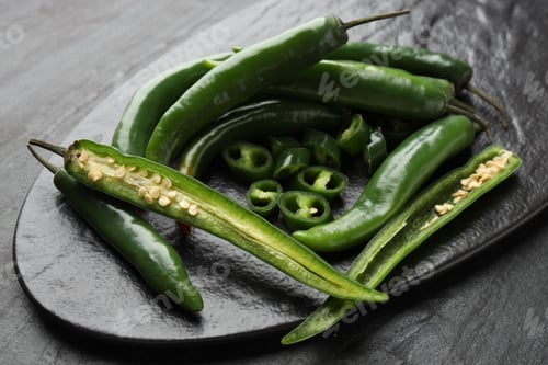 Preview: Fresh chili peppers on black table, closeup