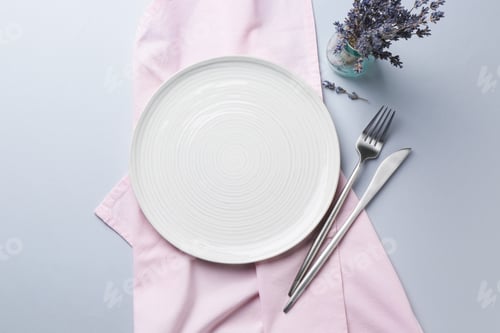 Preview: Stylish setting with plate, cutlery and lavender flowers on light grey table, flat lay