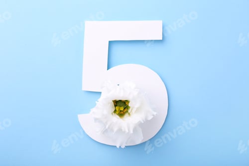 Preview: Paper number 5 and beautiful flower on light blue background, top view