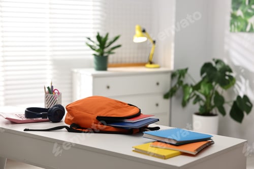 Preview: Backpack, headphones and school supplies on white desk indoors. Space for text