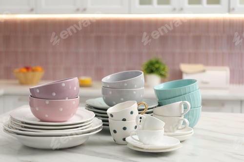 Preview: Different clean dishware on white table in kitchen. Space for text
