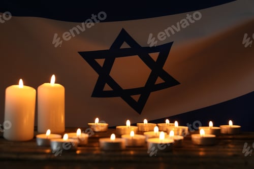 Preview: Holocaust Remembrance Day. Burning candles on table against flag of Israel, closeup