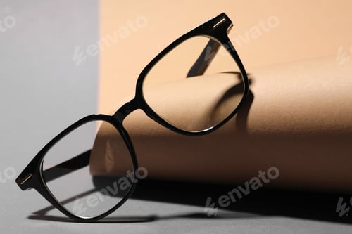 Preview: Pair of eyeglasses on color background, closeup