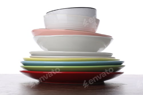 Preview: Stack of clean dishes on wooden table against white background