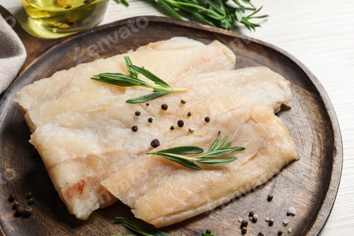 Preview: Raw cod fish, rosemary and spices on white wooden table, closeup