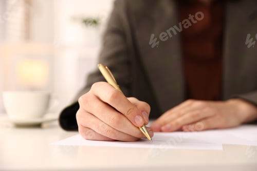 Preview: Woman writing on sheet of paper with pen at table, closeup