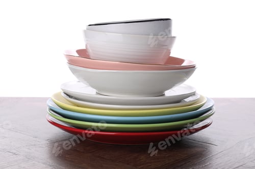 Preview: Stack of clean dishes on wooden table against white background