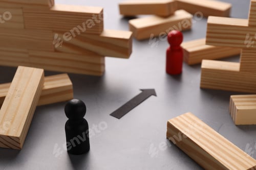 Preview: Collapsed wooden wall made of blocks, paper arrow and human figures on grey table, closeup. Overcomi