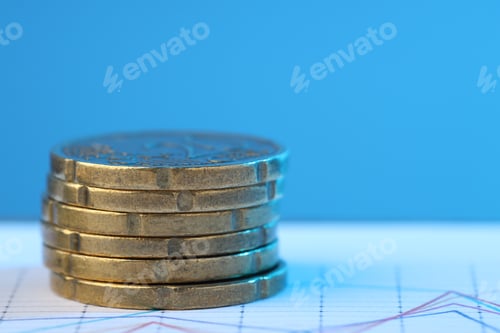 Preview: Stack of coins on chart against light blue background, closeup. Space for text