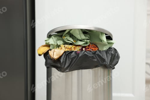 Preview: Metal trash bin full of garbage in kitchen, closeup