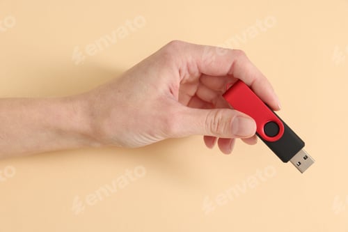 Preview: Woman with USB flash drive on beige background, closeup