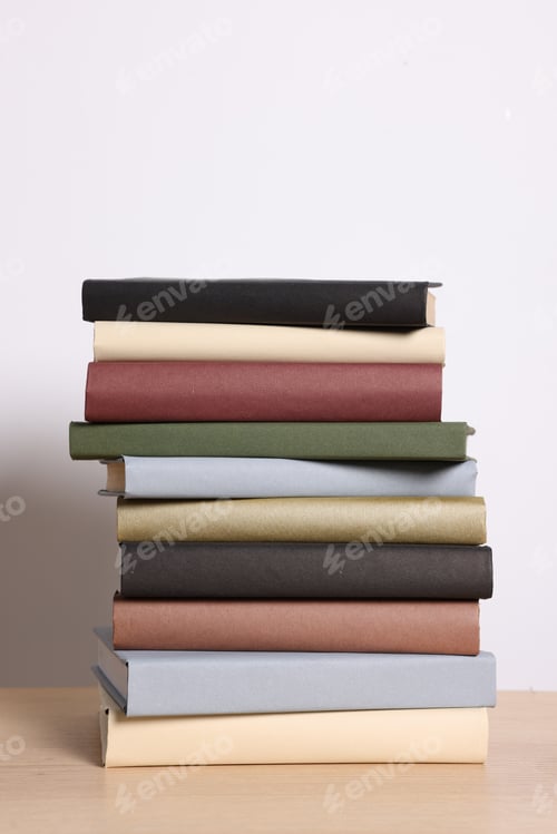 Preview: Stack of many books on wooden table against light background