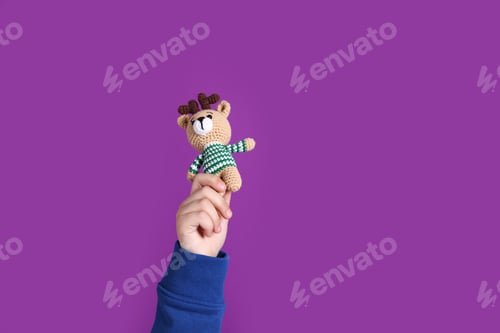 Preview: Child with toy deer on purple background, closeup. Space for text