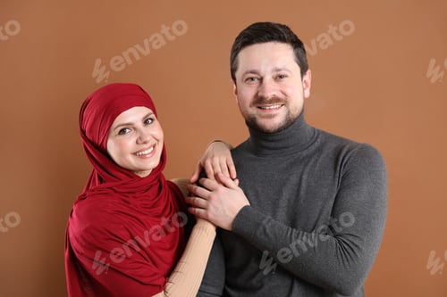 Preview: Portrait of happy muslim couple on brown background
