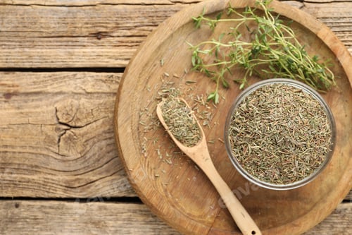 Preview: Dried thyme in bowl, spoon and fresh leaves on wooden table, top view. Space for text