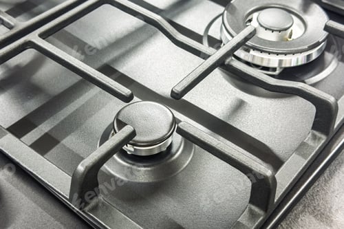Preview: Close up detail of modern new clean gas stovetop burner and cast iron grates for kitchen appliance