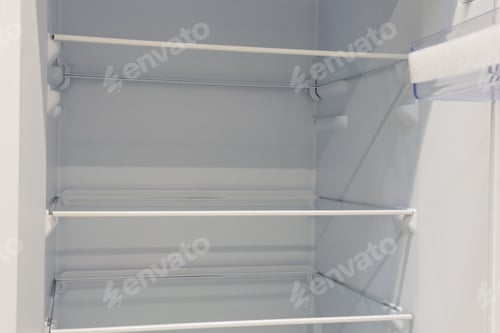 Preview: Clean white empty refrigerator interior showing glass shelves and transparent door compartment