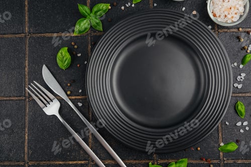 Preview: Black plate with fork and knife on dark background