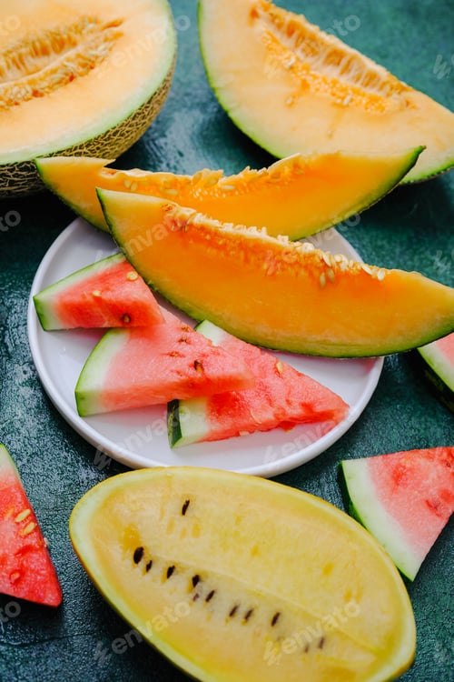 Preview: Sweet melon and watermelon slices arranged on dark surface. Refreshing summer fruit