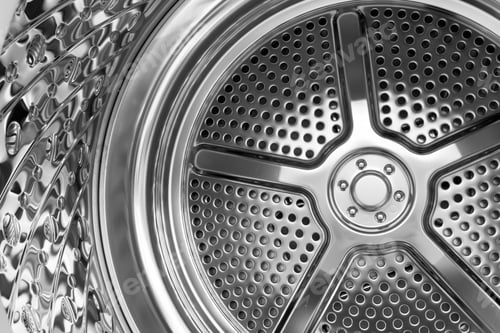 Preview: Reflective perforated metal surface inside a contemporary washing machine drum
