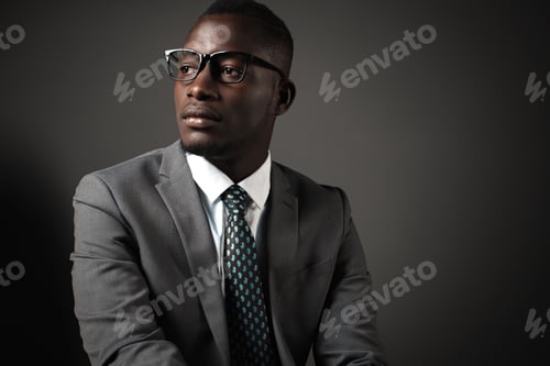 Preview: Serious young black man with glasses and gray business suit